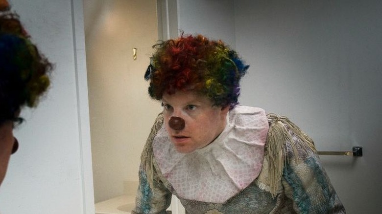 Clown looks in the mirror