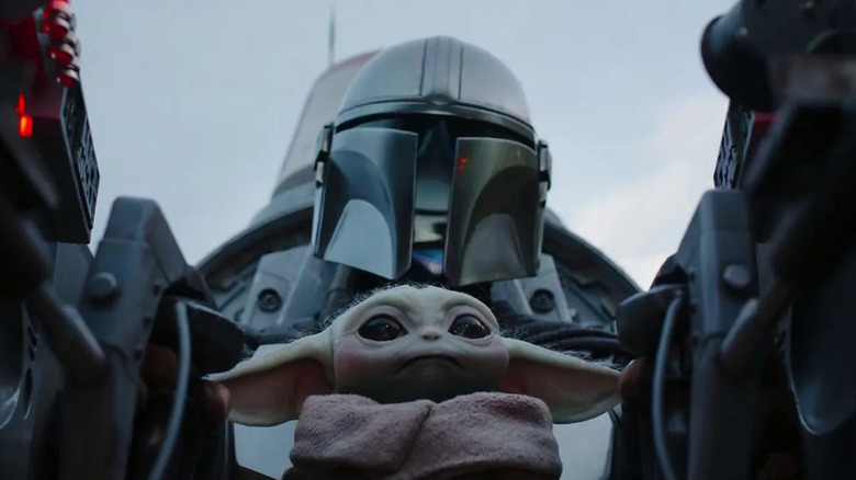 Mando with Grogu in a cockpit in "The Mandalorian"