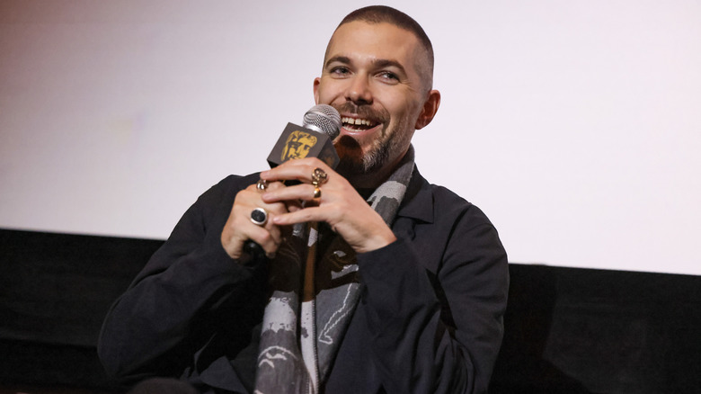 Robert Eggers smiling and holding a microphone