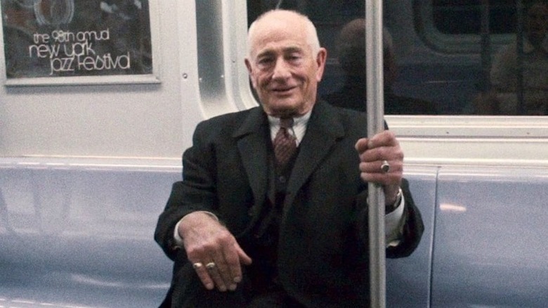 Uncle Hank sits on a subway and smiles in Black Swan (2010)