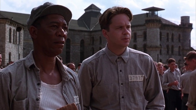 Red and Andy stand in the prison yard looking into the distance in The Shawshank Redemption (1994)