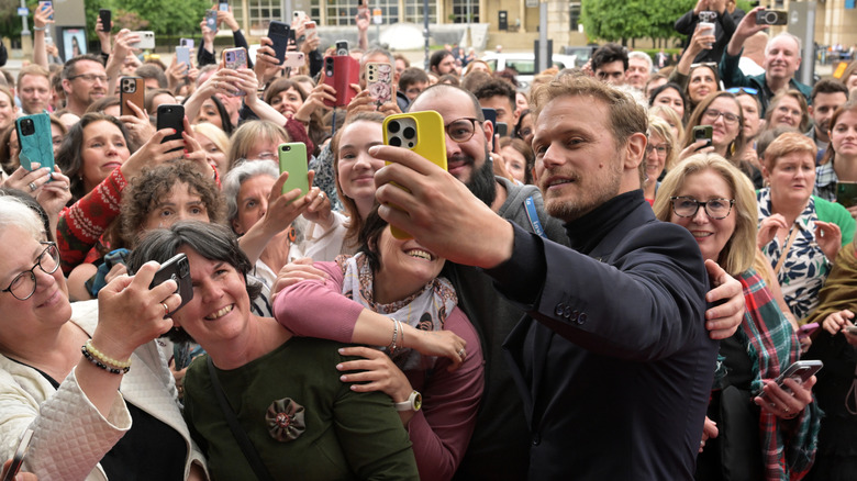 Sam Heughan posing with Outlander fans