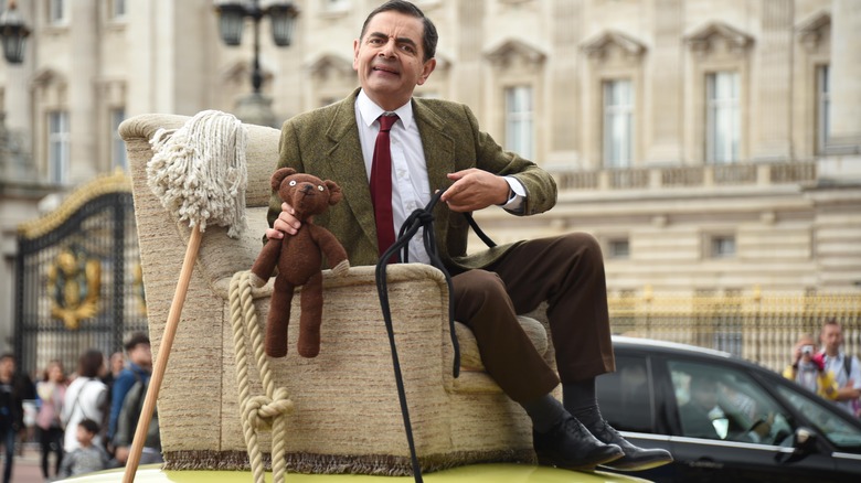 Mr. Bean riding on car roof