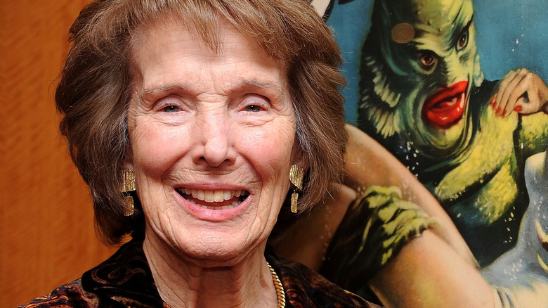 Julie Adams in front of a movie poster