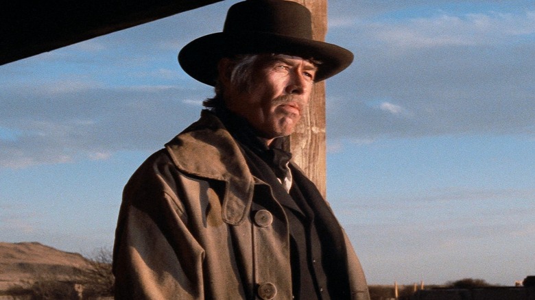 Pat Garrett stands on a porch in 