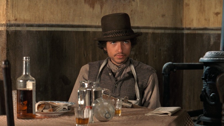 Alias sits in a bar in "Pat Garrett and Billy the Kid" (1973)