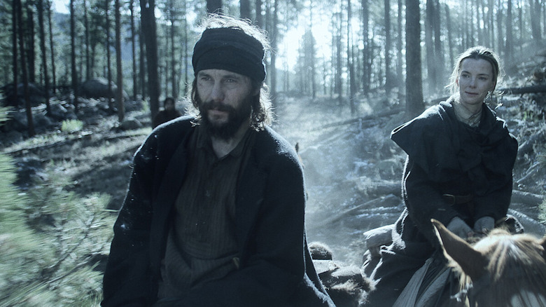 Isaac and Sara on horseback in the woods in American Primeval