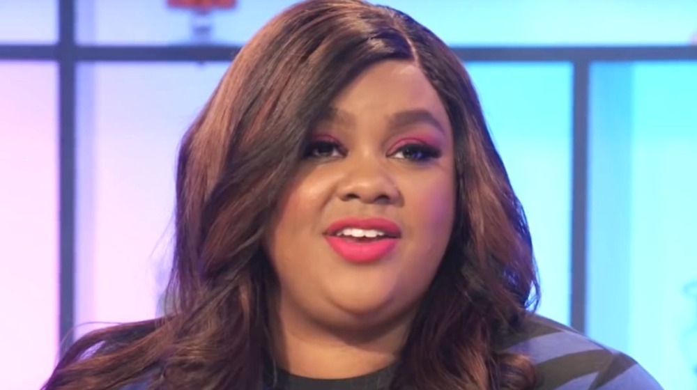 Nicole Byer slightly smiling