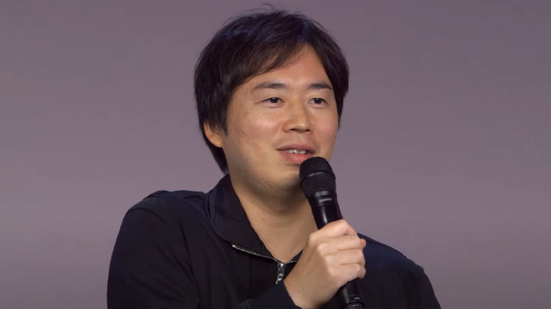 Kishimoto holding a mic in 2015 during a live Q&A