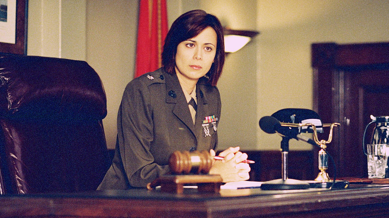 Sarah MacKenzie sits behind her desk on "JAG"