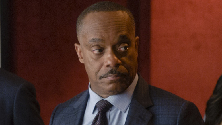 Leon Vance staring blue suit and tie