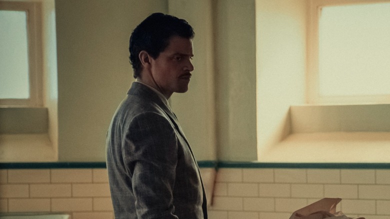 Charles Whiteman standing over a body covered with a sheet