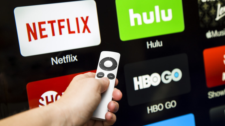 A tv remote pointed at a screen with various streaming services available