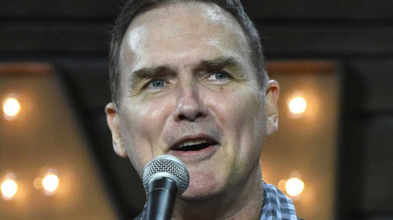 Norm Macdonald speaking into a microphone