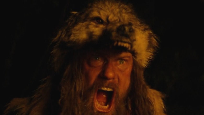 Alexander Skarsgård as Amleth roars as he wears a wolf head on his own, in The Northman
