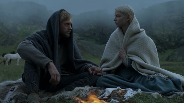 Alexander Skarsgård as Amleth and Anya Taylor-Joy as Olga sit around a campfire in The Northman