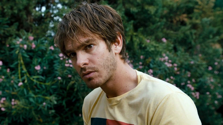 Sam standing near some bushes in 2018's Under the Silver Lake