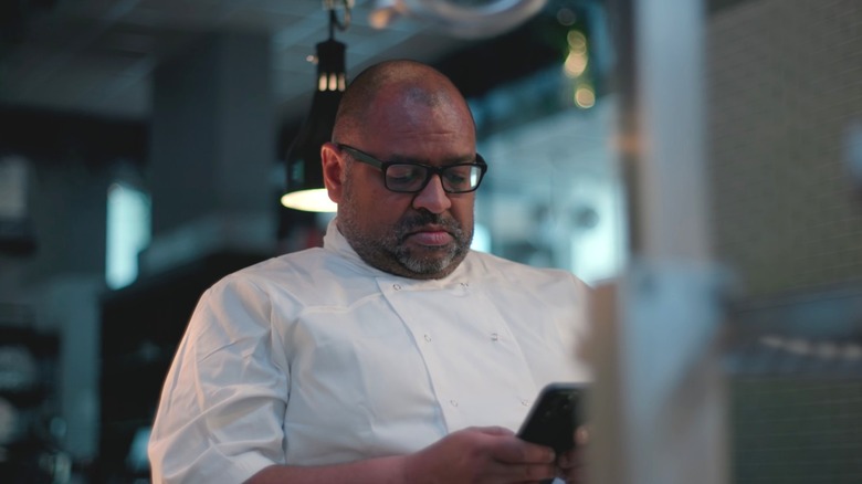 Graham Hornigold checking his phone in "Con Mum"