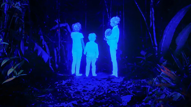 Four children glowing blue in a dark forest in "The Lost Children"