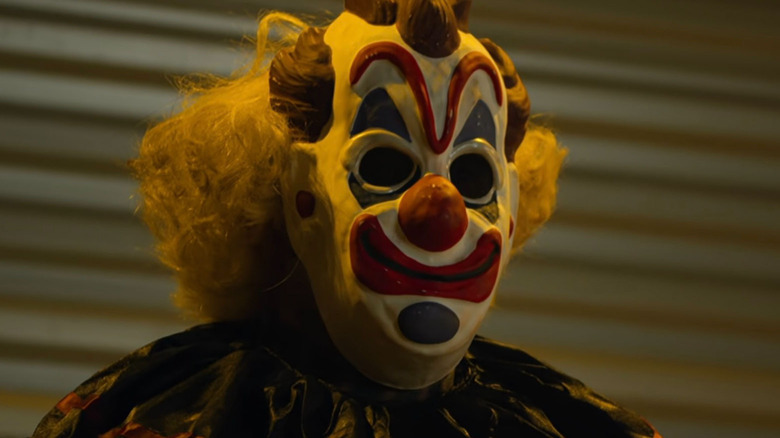 Person wearing scary clown mask