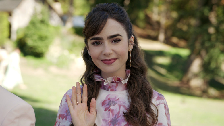 Emily waves outdoors