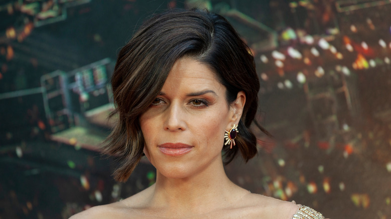Neve Campbell looks off to side on red carpet