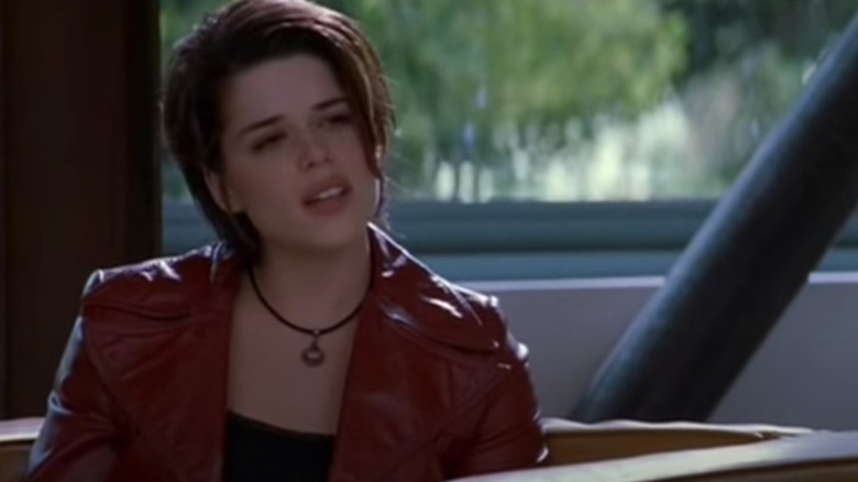 Neve Campbell sits in sunny waiting room
