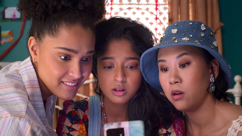 Fabiola, Devi, and Eleanor looking at Devi's phone