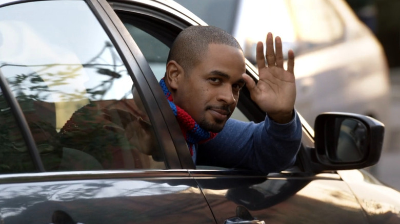 Coach leaning out car window and waving goodbye