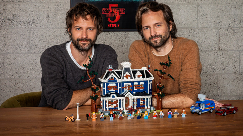 Duffer Brothers posing next to the Creel House LEGO set
