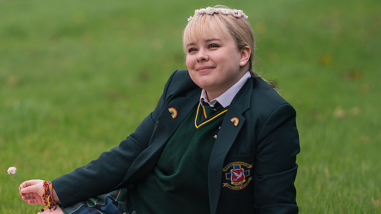 Clare lounging in a field in "Derry Girls"