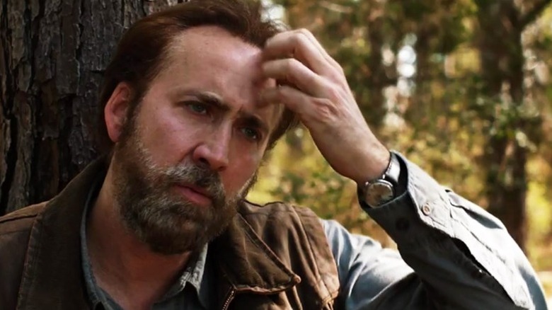 Nic Cage with hand against head in Joe