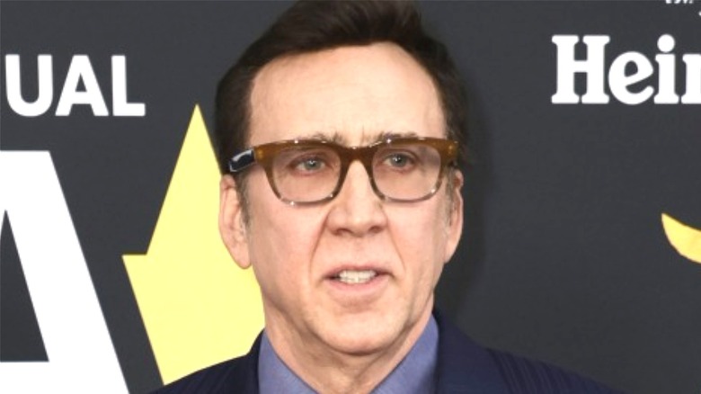 Nicolas Cage in a suit and glasses
