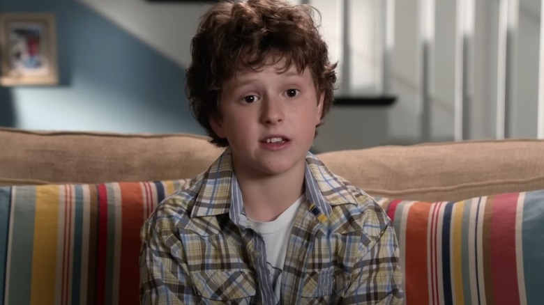 Luke Dunphy sitting on the couch on Modern Family