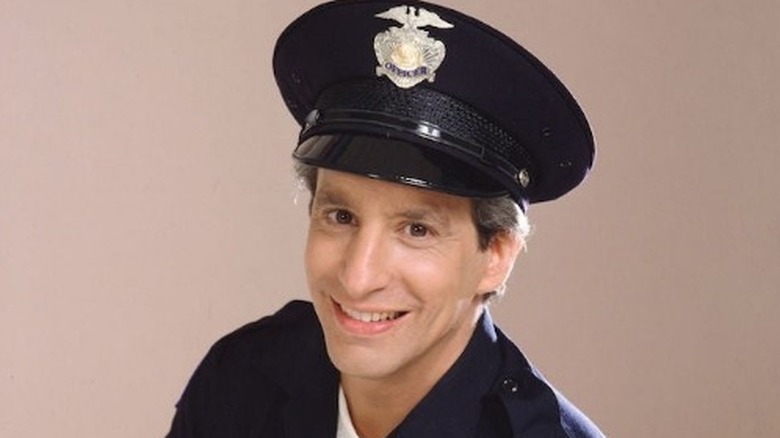   تشارلز ليفين يبتسم في زي ضابط الشرطة