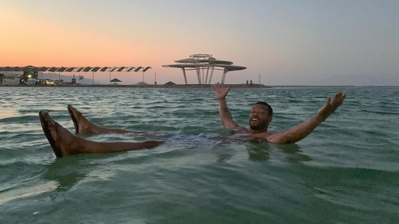 Isaiah Mustafa floating on top of the water in the Dead Sea