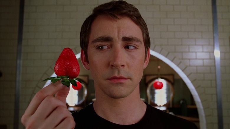 Ned looking at a bright strawberry