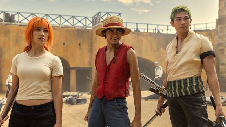Luffy, Zoro, and Nami holding swords