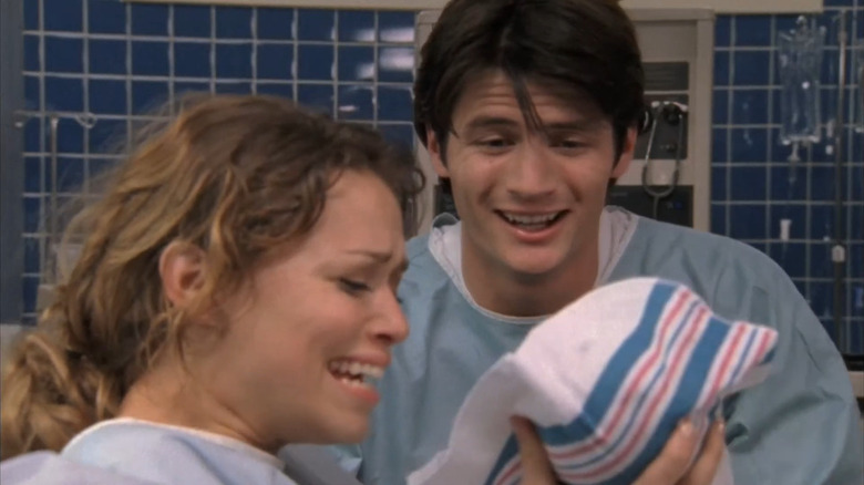 Haley and Nathan smiling at newborn