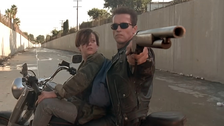 The T-800 points his gun on a motorcycle with John Connor in 