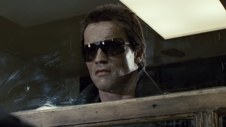 The T-800 in sunglasses looking through a window in 
