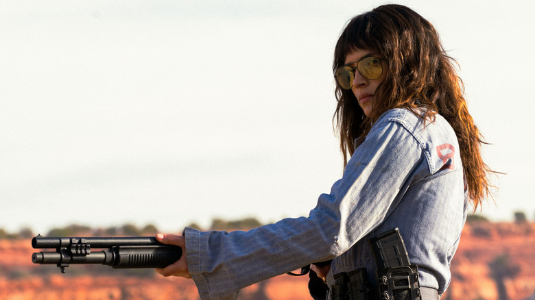 Celeste holding a shotgun in the desert in "Onslaught" (2026)