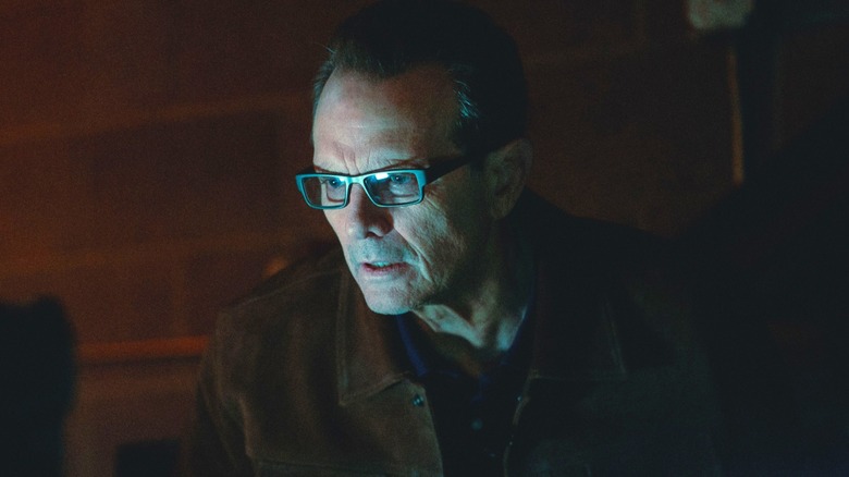 Baylor staring in terror at a computer screen in a dark room in "Onslaught" (2026)