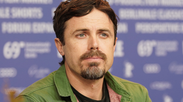 Casey Affleck wears a green shirt