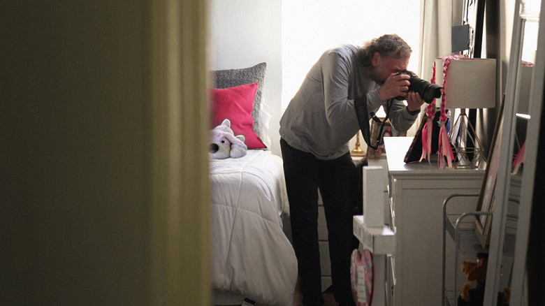Man taking a photo in All The Empty Rooms