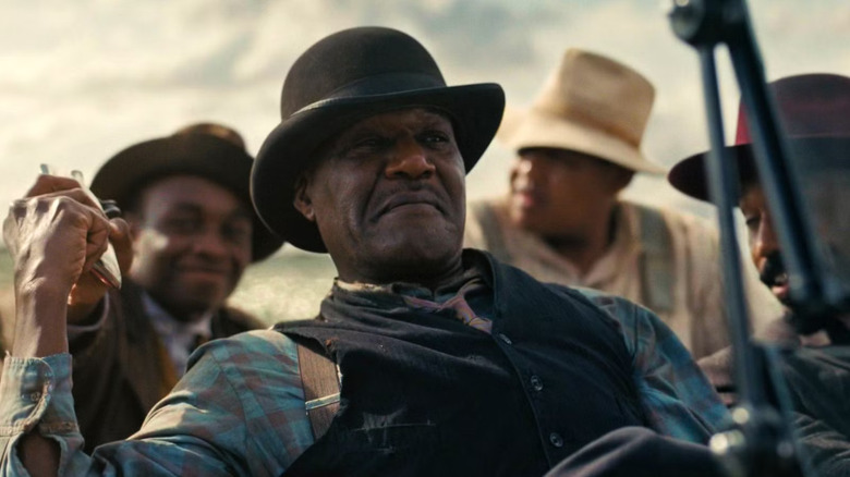 Delta Slim leaning back in the car in Sinners