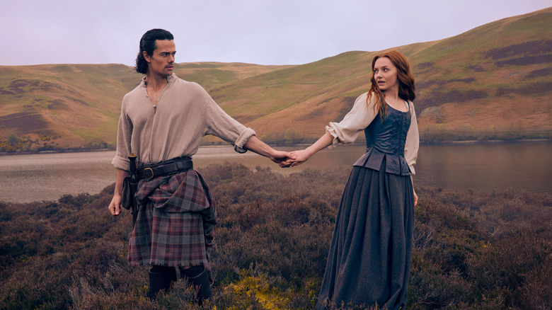 Brian and Ellen holding hands in field