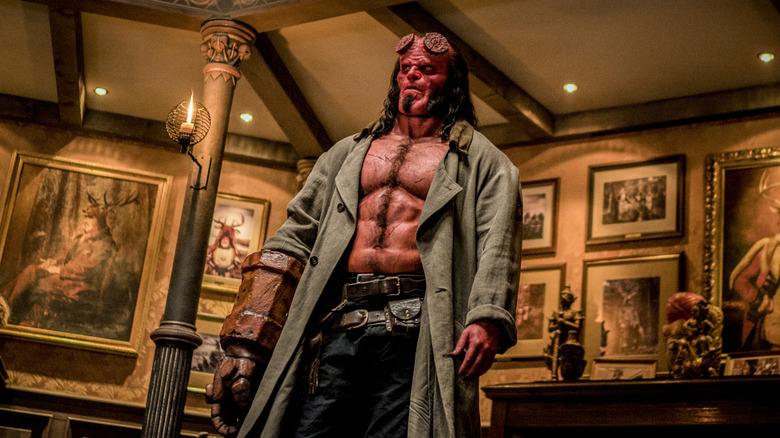 Hellboy standing in the middle of a room surrounded by paintings