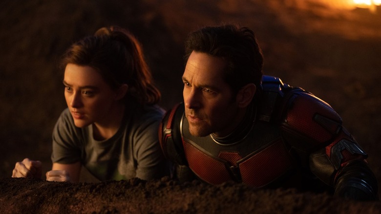 Cassie and Ant-Man crouched behind a rock in Ant-Man and the Wasp: Quantumania (2023)