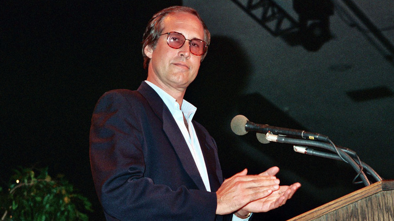 Chevy Chase clapping at podium